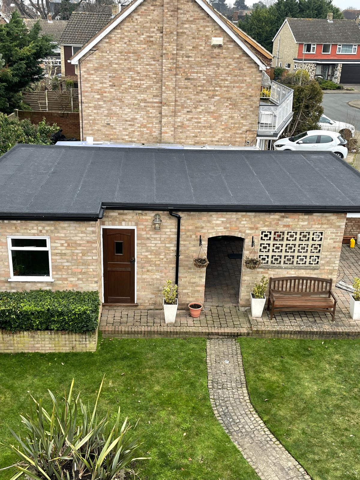 Completed flat roof installation on a brick home extension