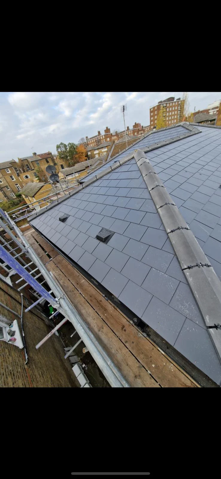 New slate roof installation viewed from scaffold walkway