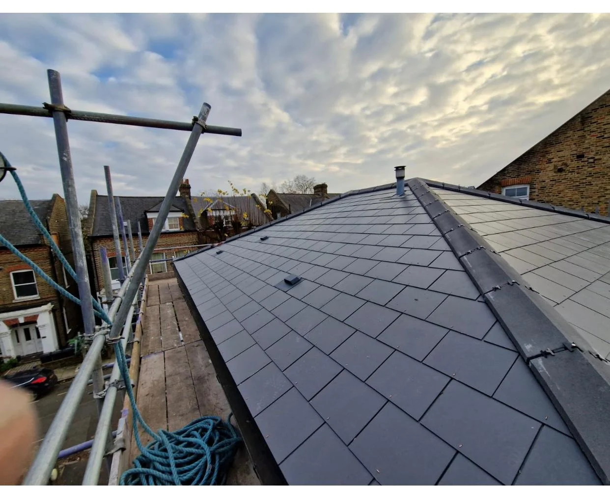 Completed slate roof with ridge detail under evening sky